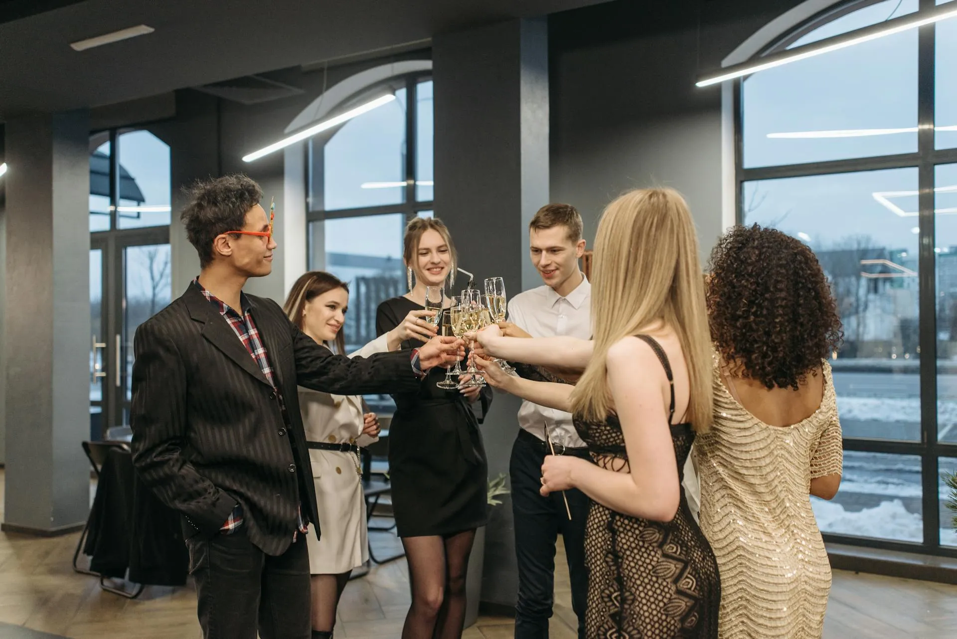 Group of guests in cocktail attire celebrating with champagne