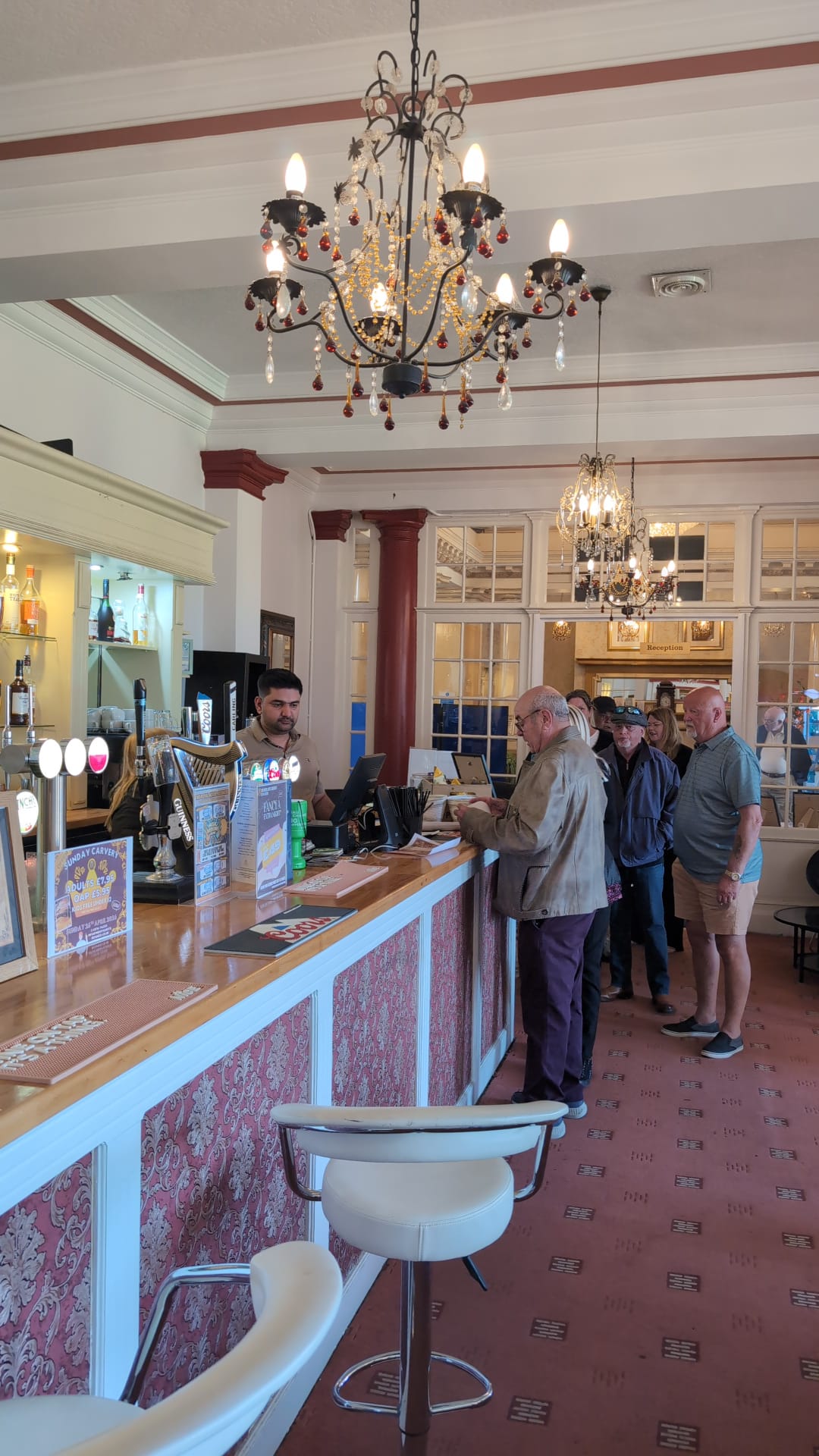 Busy bar beneath a crystal chandelier