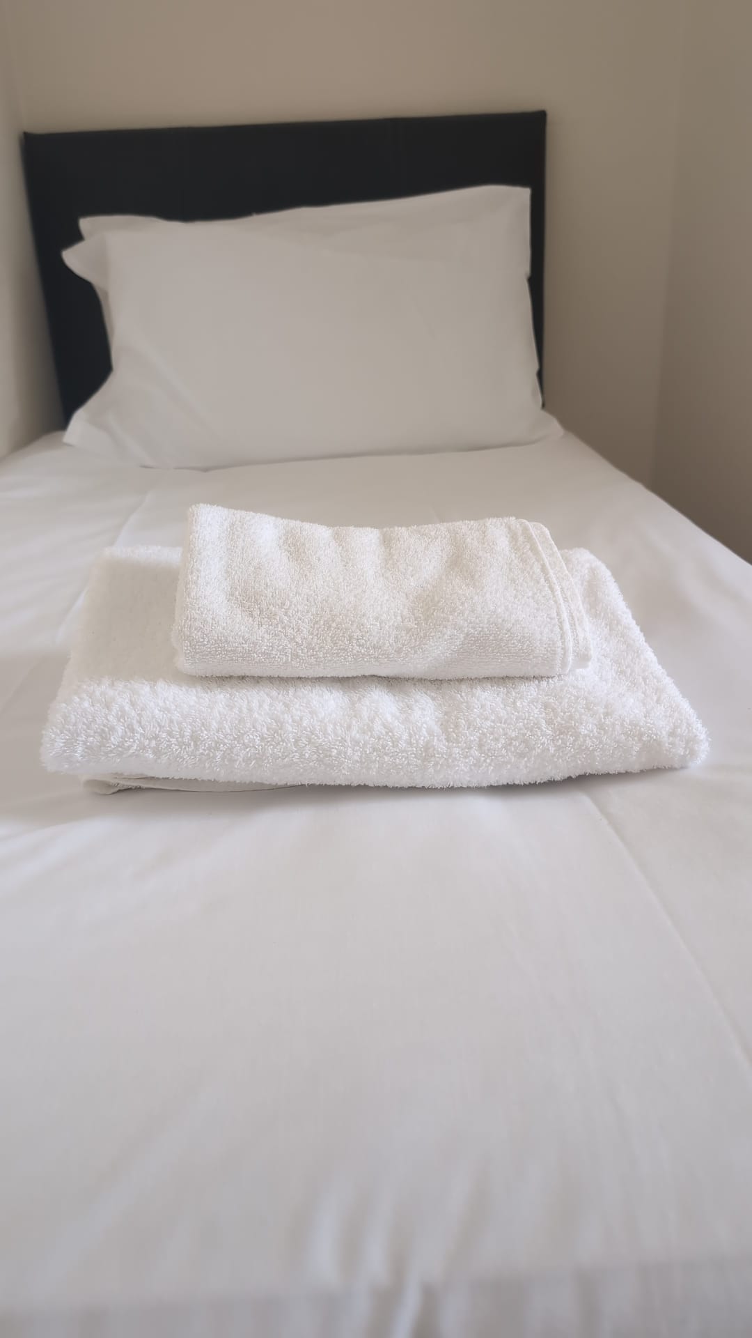 Single bed with folded towels