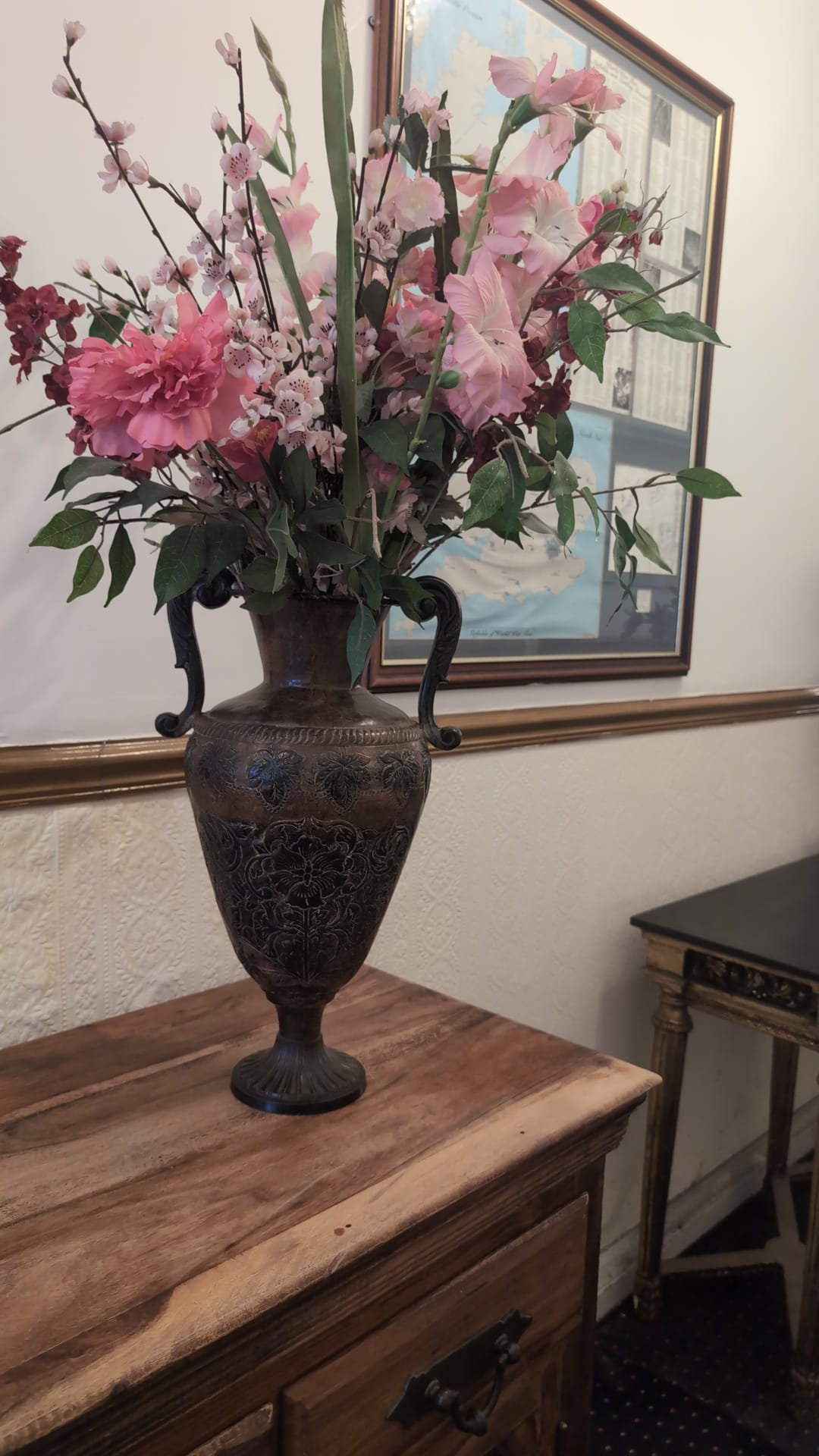 Bronze urn with pink flowers on wood console - The Royal Hotel, Skegness